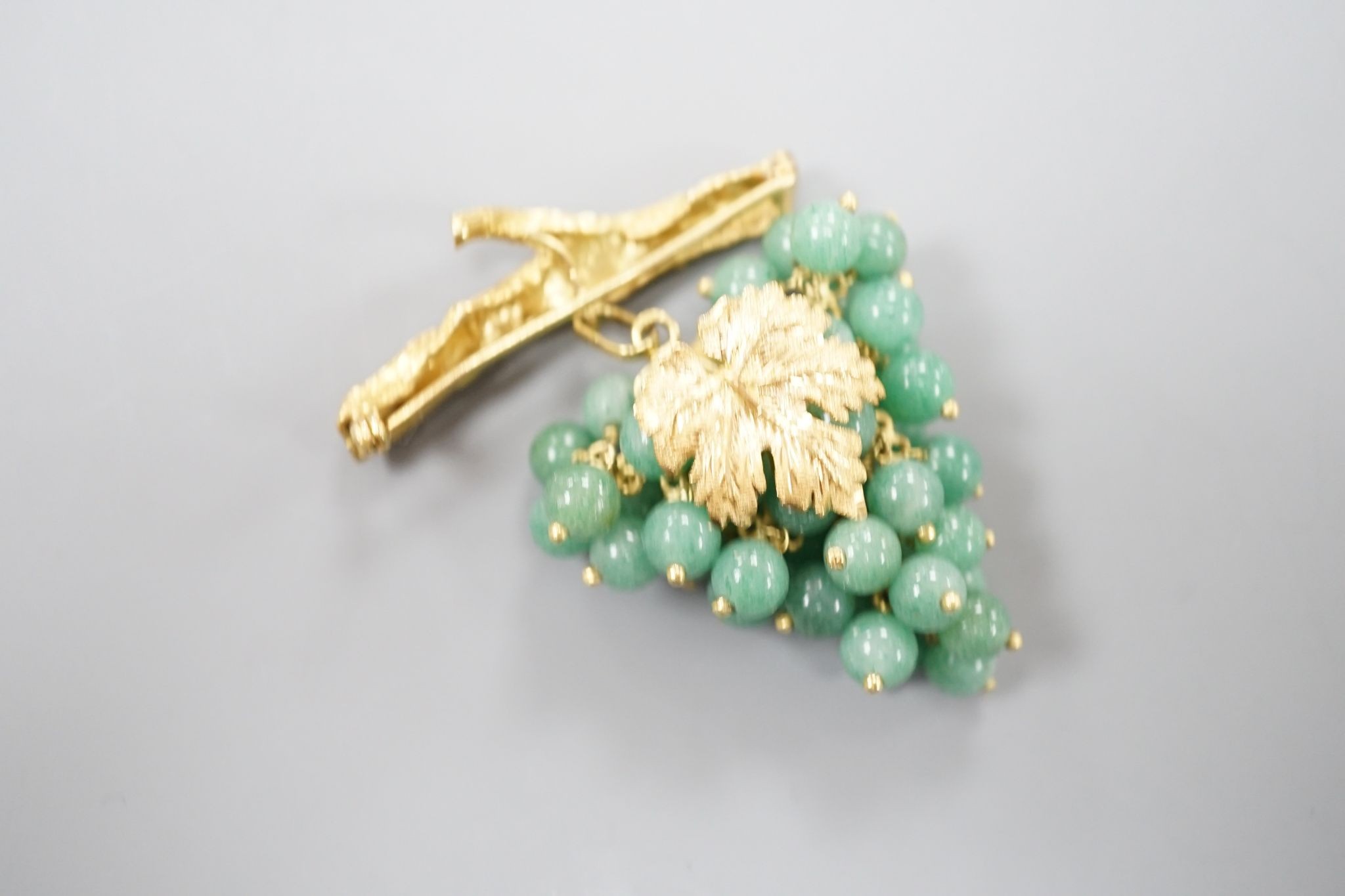 A 20th century continental 18k yellow metal and adventurine quartz bead set brooch, modelled as a bunch of grapes hanging from a branch, 59mm, gross weight 30.4 grams.